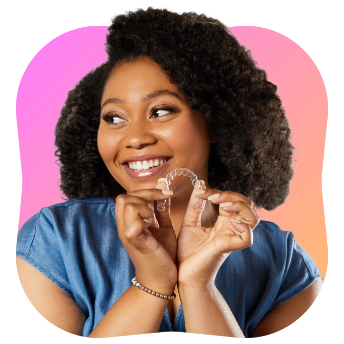 Woman holding a SureSmile clear aligner - Pacific Signature Dental Vancouver
