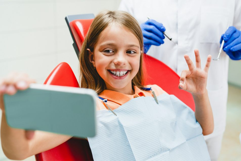 Happy patient giving the OK sign in the dental chair